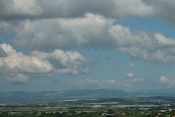 A landscape with clouds and mountains in the background. Sky. Outdoor. Mountain. Nature. Clouds