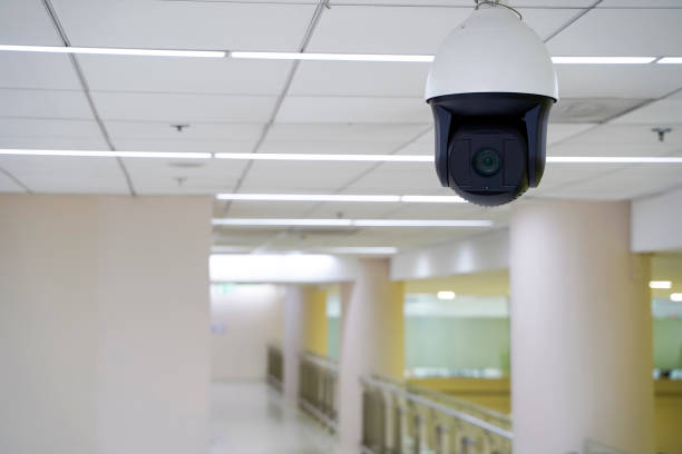 istock A camera is mounted on the ceiling of a hallway. Security CCTV camera in office building. 2157727409