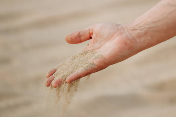 istock A man's hand pouring sand in the desert in Qatar 2157729365