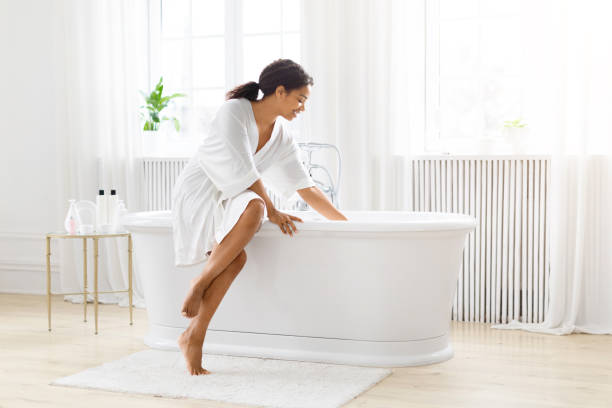 istock Contemplative black woman by a standalone bathtub 2157729748