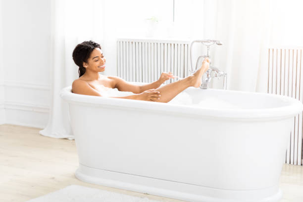 istock Woman relaxing in a bubble bath, shaving legs 2157729751