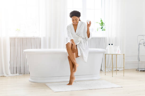 istock Woman putting on cream sitting on tub 2157729778