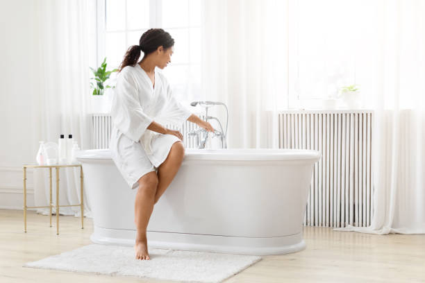 istock Woman preparing for a bath in bright room 2157729812
