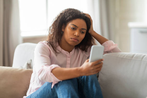 istock Lady with phone looking upset at home 2157730009