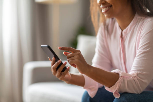istock African American Lady Browsing on Phone While Relaxing at Home 2157730079