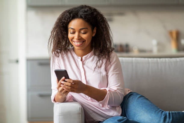 istock Content Young Black Woman Texting on Couch at Home 2157730096