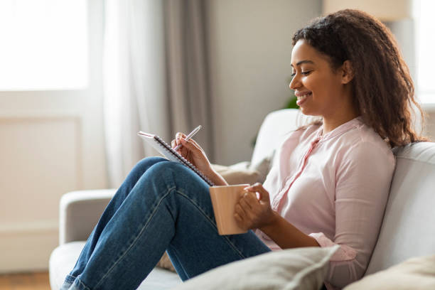 istock Joyful Moments: Young Woman Journaling with Coffee at Home 2157730121