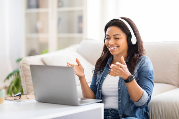 istock Woman Sitting on Floor, Using Laptop and Headset 2157730329