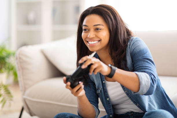 istock Woman Sitting on Couch Holding Remote Control 2157730356