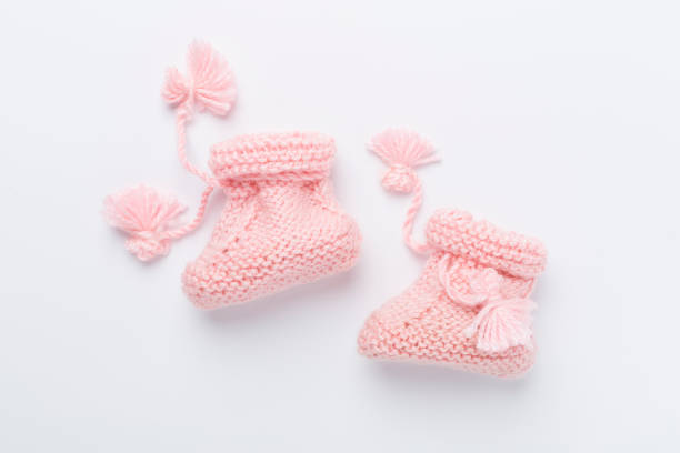 Warmly dressed infant sitting and holding toes