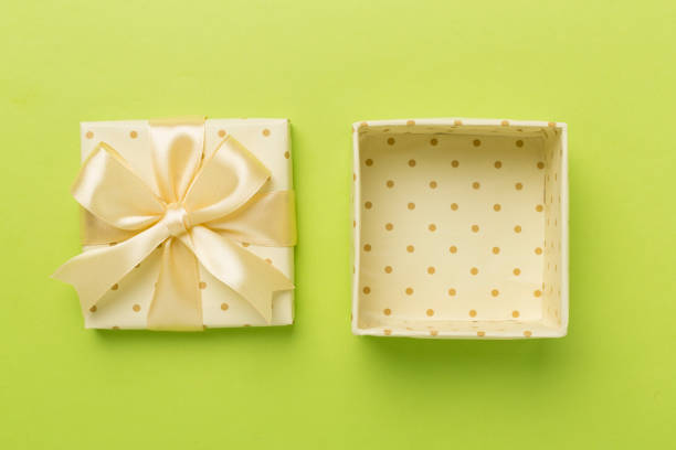 Beige open gift box on color background, top view