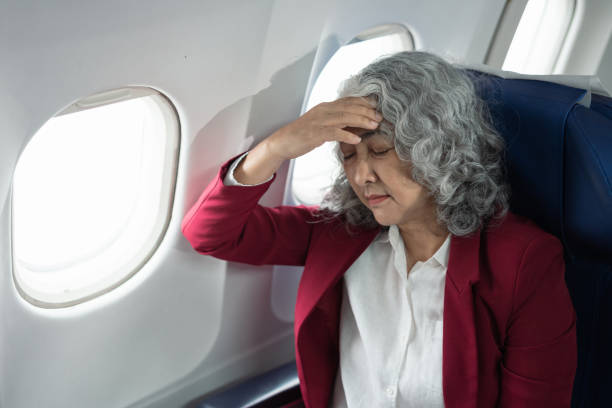 istock Mature with headache with nausea feeling sick while sitting in the airplane , Passengers near the window. 2157738212