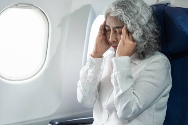 istock Mature with headache with nausea feeling sick while sitting in the airplane , Passengers near the window. 2157738213