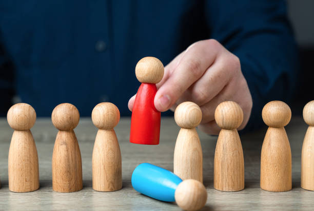 istock Replace another employee with a loyal and subordinate one. Replacing an old worker with a more productive one. Human resources and HR policy. Installing a subservient leader, easily influenced 2157739401