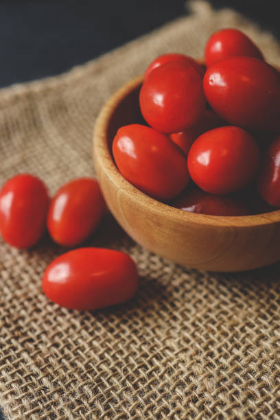 Fresh tomatoes in a plate on a dark background. Harvesting tomatoes.