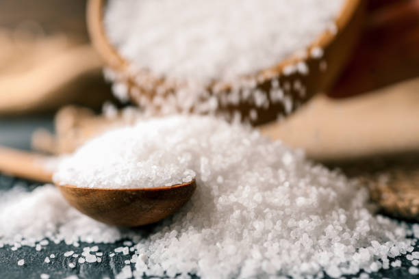 istock Pour salt into a wooden spoon, close-up 2157739655