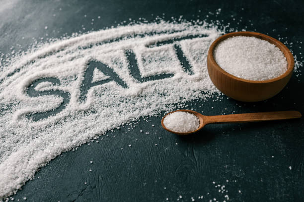 istock Heap of white salt on dark background with text SALT 2157739664