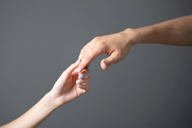 istock A close-up view captures the tender touch between a mans and a womans hand against a neutral gray backdrop. 2157740192