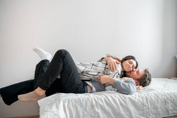 istock A joyful couple engages in a lighthearted and playful activity on a cozy bed in a well-lit room, sharing a moment of laughter and fun. 2157740200