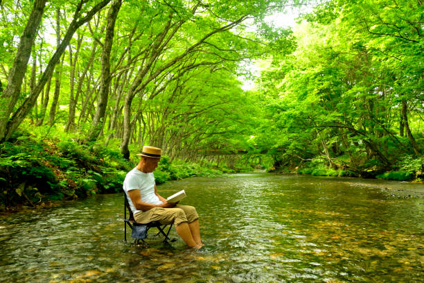 Senior man enjoying the coolness of a mountain stream