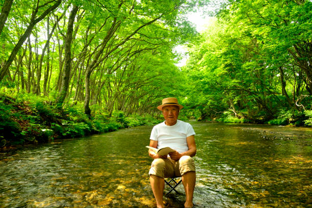 istock Senior man enjoying the coolness of a mountain stream 2157741021