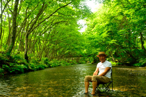 istock Senior man enjoying the coolness of a mountain stream 2157741033