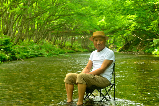 istock Senior man enjoying the coolness of a mountain stream 2157741044