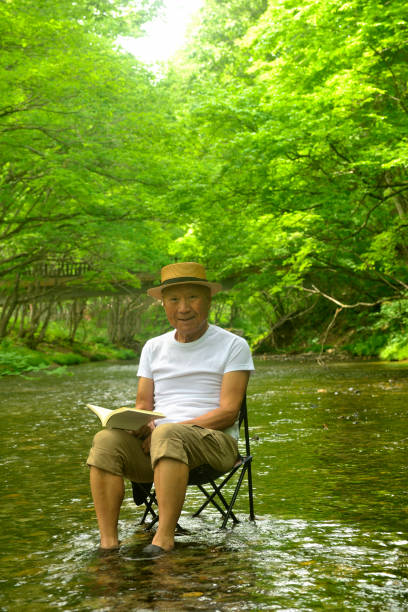 istock Senior man enjoying the coolness of a mountain stream 2157741105
