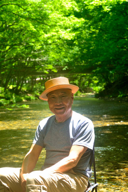 istock Senior man enjoying the coolness of a mountain stream 2157741318