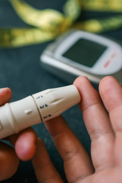 istock Man measuring blood sugar, close-up 2157741686