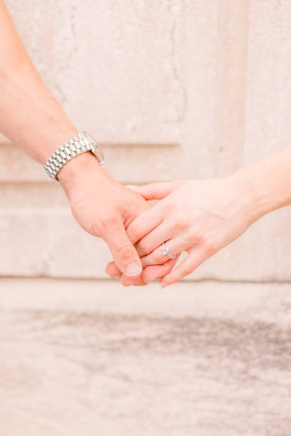 istock A couple is holding hands together against a stone background. 2157742993