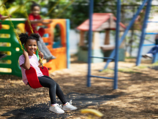 istock Little girl using a swing on a daycare playground 2157743057