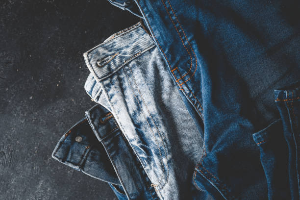 istock Stack of Various Shades Of Blue Jeans On White Background Denim jeans texture 2157743385