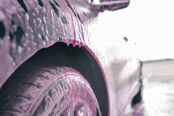 Hand washing car with pink foam, advertising.