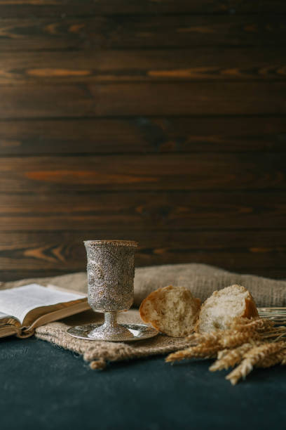 istock Cup with wine, bread and open Bible, Christian communion 2157746648