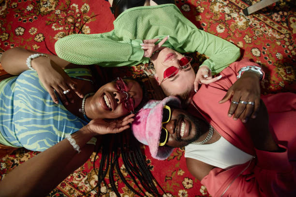 Top View Three Trendy People Lying on Ornate Carpet