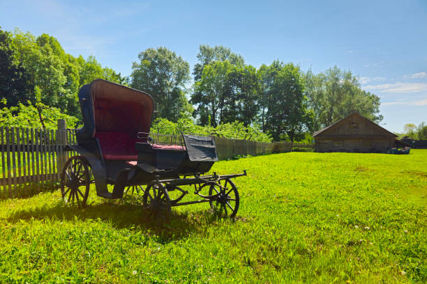 An ancient phaeton carriage on a green rural lawn. Izvara. Leningrad region, Russia.
