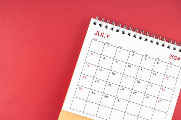 July 2024 desk calendar on red background.