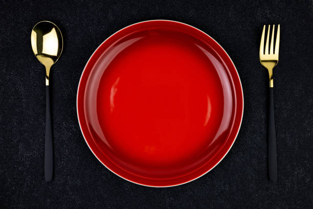 istock Red plate with fork and spoon mockup on black concrete background top view 2157764461