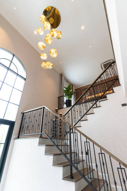 Beautiful staircase with gold chandelier hanging from above. Beautiful staircase with gold chandelier hanging from above in luxury home. stairwell chandelier stock pictures, royalty-free photos & images