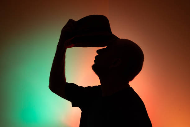 istock Studio portrait of a man holding hat in silhouette. 2157773666