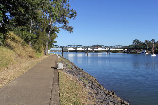 istock Riverside pathway lined with trees leading to the Burnett Bridge spanning a river in Bundaberg, Queensland, Australia 2157779059