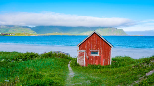 istock Red Cabin on a Norwegian Beach, Ramberg Beach Lofoten Norway 2157784004