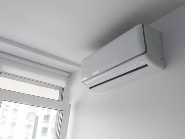 istock Modern air conditioner hanging on light wall in room 2157787888
