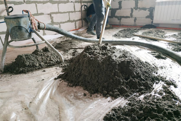 istock The worker performs a sand-cement floor screed above the floor heating. 2157790120