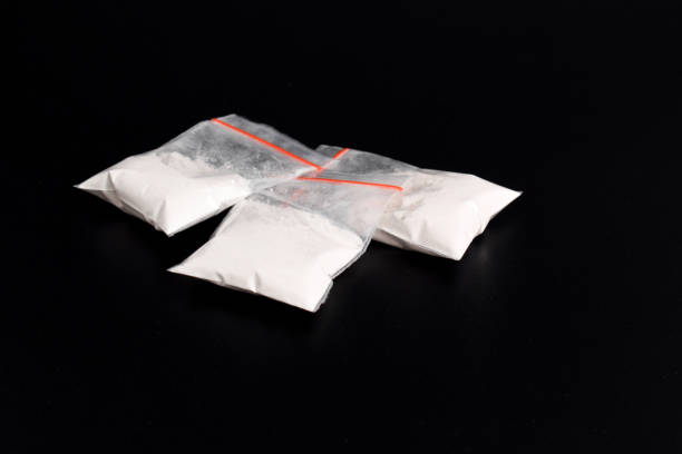 istock Cocaine in plastic packet on black background. illegal drugs 2157792613