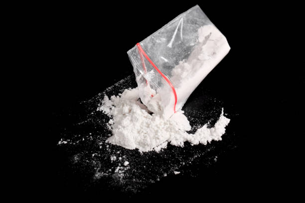 istock Cocaine in plastic package sprinkled on black background 2157792881