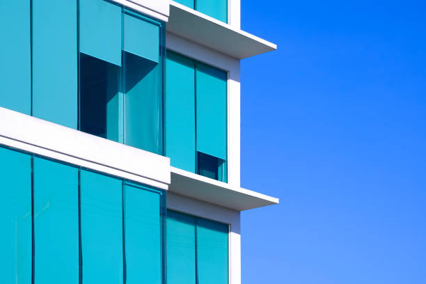 istock Modern glass office building with blue roller sun blinds against blue clear sky background in minimal style 2157793474