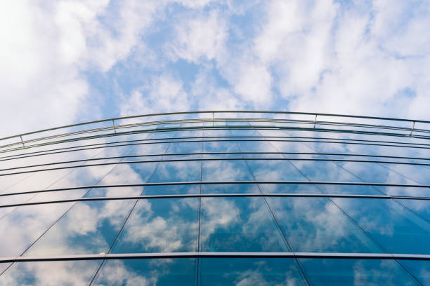 Modern style hi rise blue glass building exterior with transparent wall.