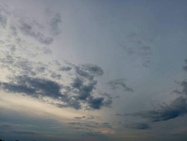 A beautiful cloudy evening sky with small gray clouds hanging high overhead.